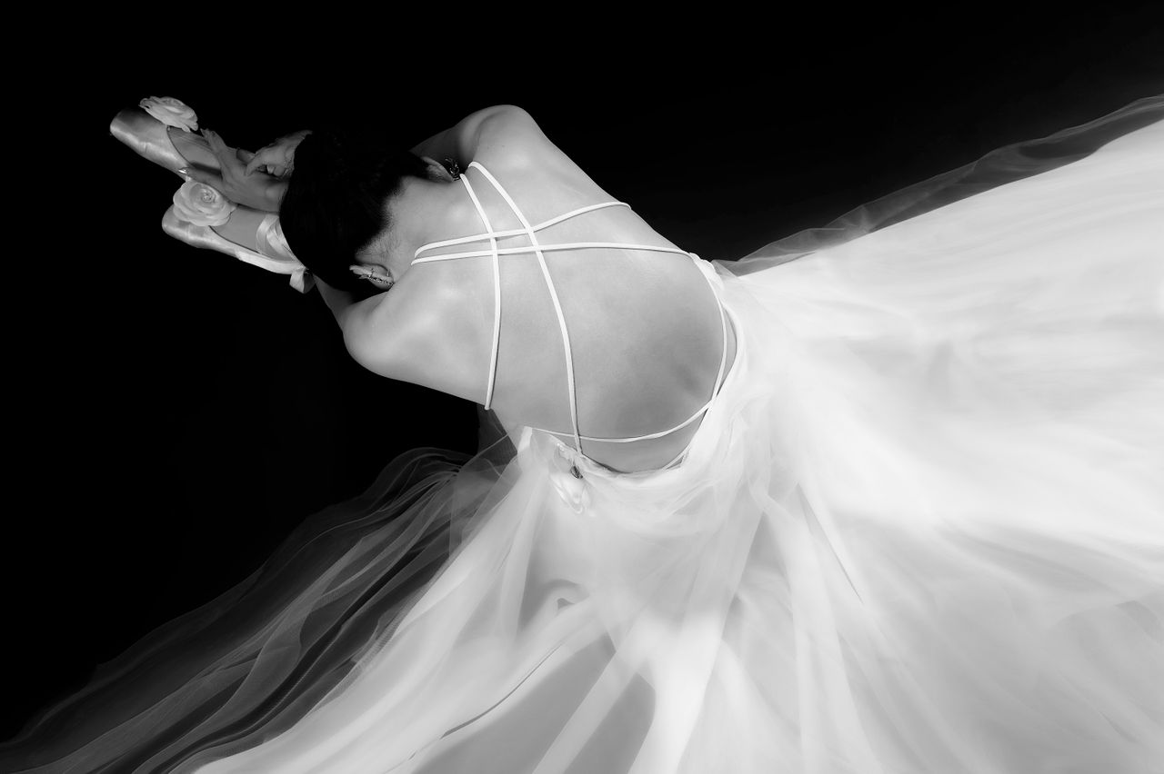 Services Graceful ballet dancer captured in a monochrome artistic pose with flowing dress.