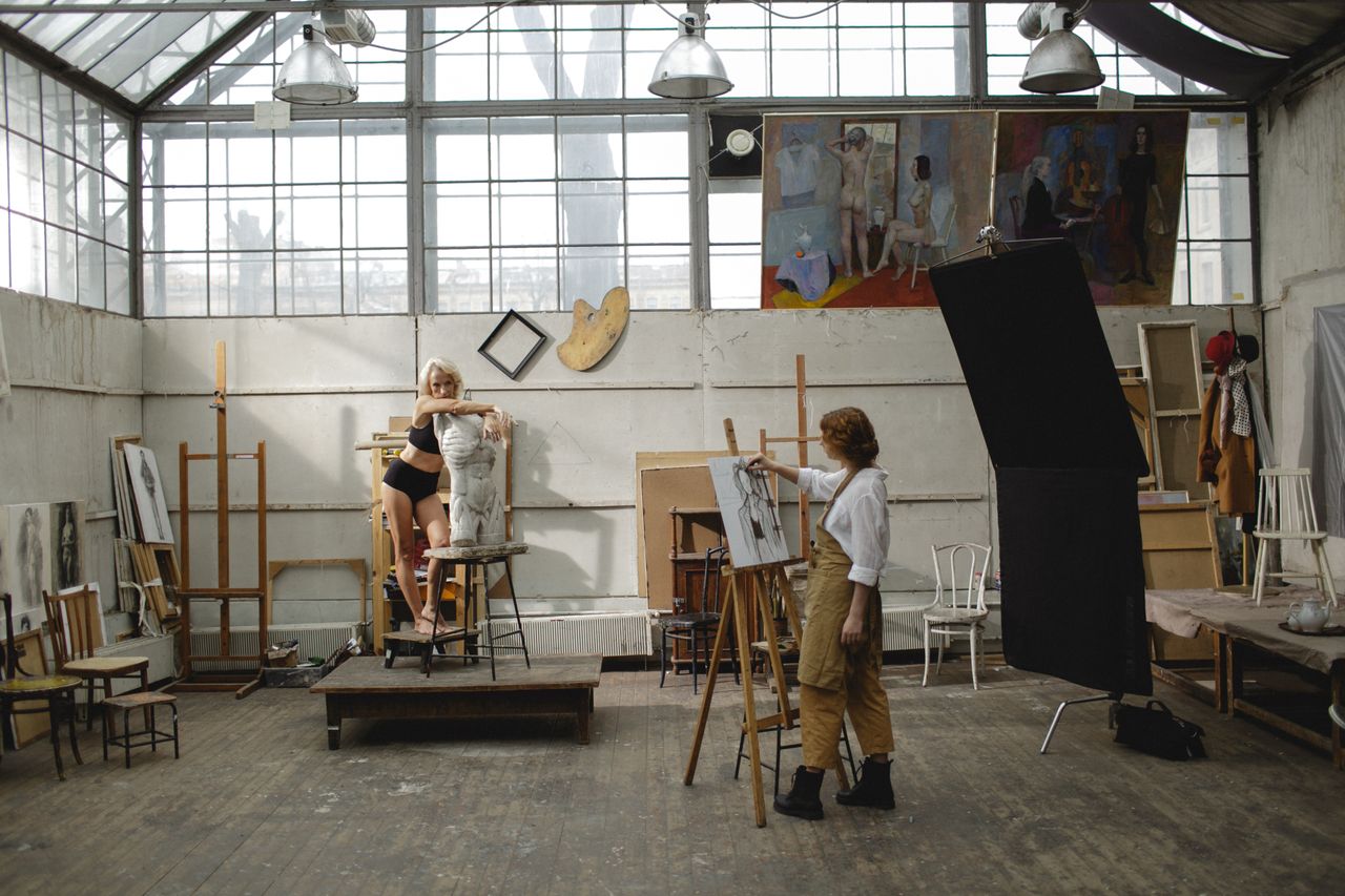 Services Art studio scene featuring an artist drawing a live model on an easel, showcasing creativity.